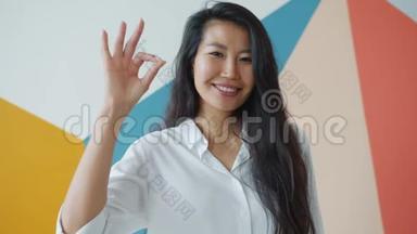 可爱的亚洲学生展示良好的手势表达幸福的肖像